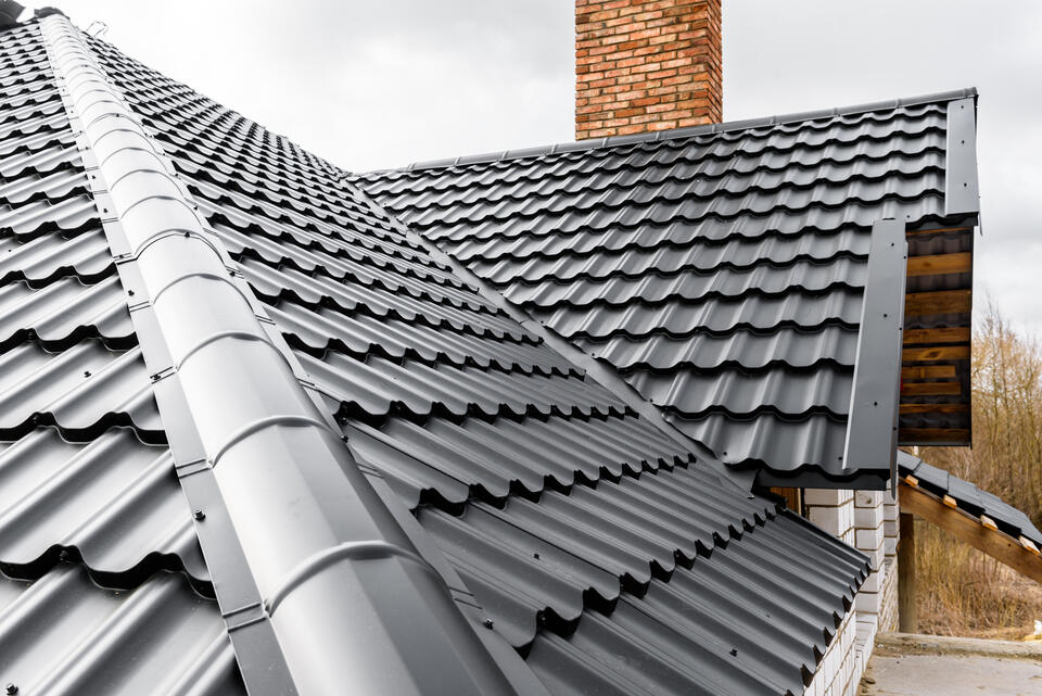 metal roofing sebastian fl-close up black metal shingles on brick house