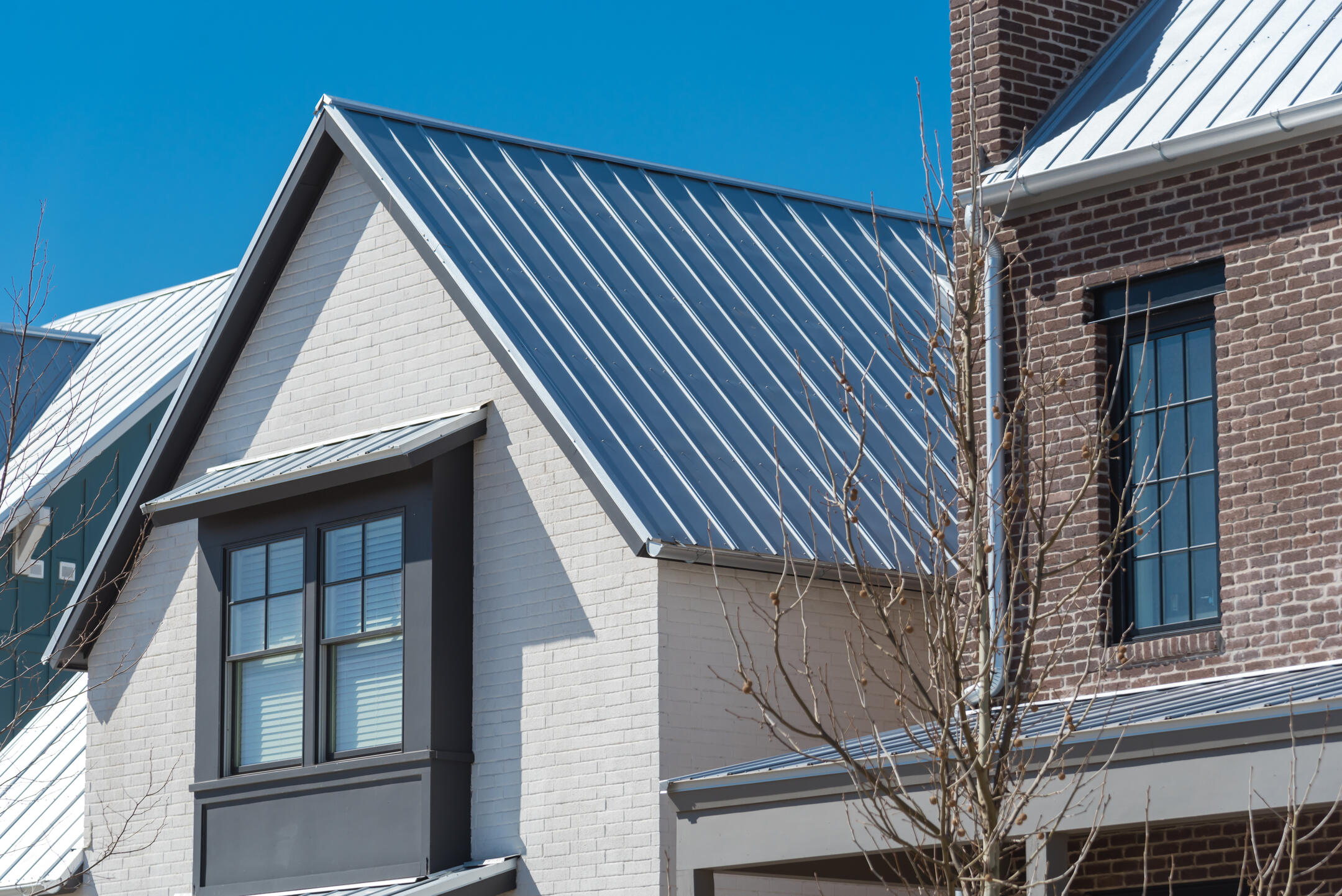 metal roofing west palm beach fl-white brick house with gray standing seam metal roof